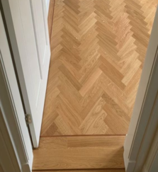 Light herringbone wood flooring at doorway transition.