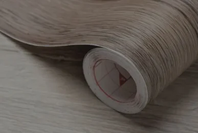 Close-up of a rolled laminate flooring sheet, showcasing texture and design, representing professional flooring services
