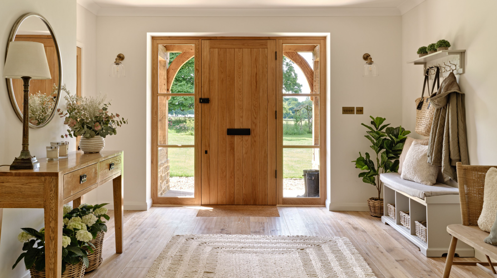 Wooden door with glass panels, a table with flowers, a bench with cushions, and plants.