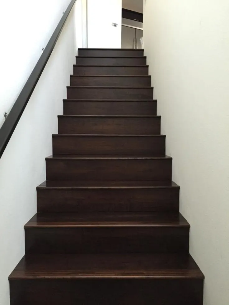 A cozy staircase featuring polished wooden steps, showcasing a warm and inviting home atmosphere.
