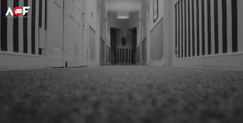 A black and white hallway scene, with light emanating from a door, creating a contrast that highlights the space's dimensions.