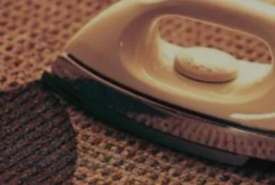 An iron burn mark on a carpet with a clothes iron placed nearby. Guide on how to get iron burns out of carpet